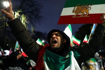 İran'lı protestocu, eski rejim bayrağıyla